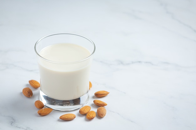 Leche de almendras con almendras sobre fondo de mármol