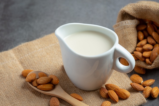 Foto gratuita leche de almendras con almendras sobre fondo oscuro