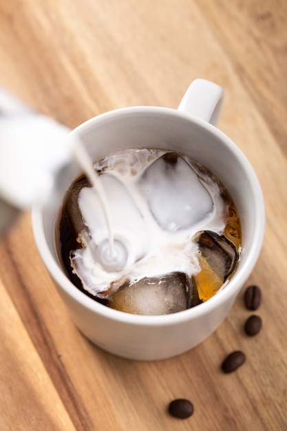 Foto gratuita leche de alto ángulo vertida en café helado