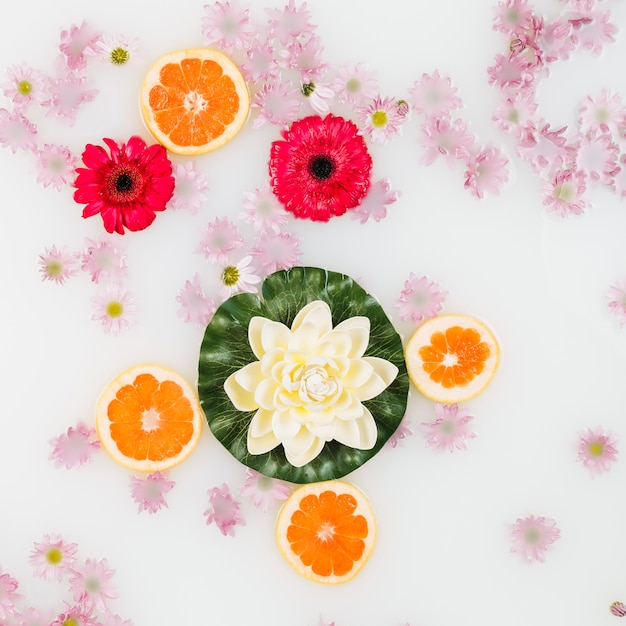 Foto gratuita leche de baño decorada con flores y rodajas de pomelo