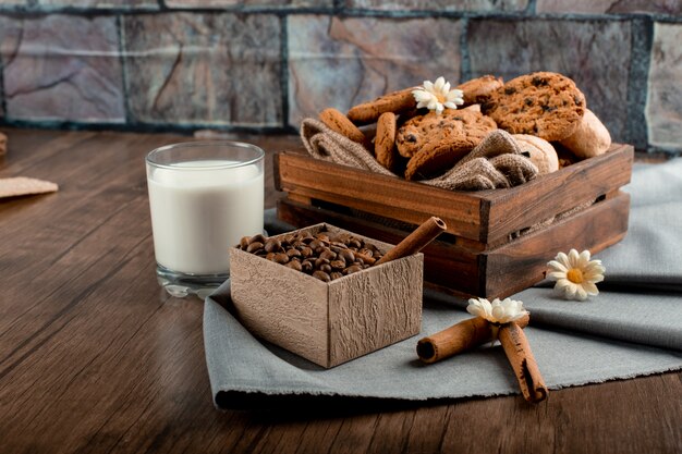 Leche, caja de café y galletas en la mesa.