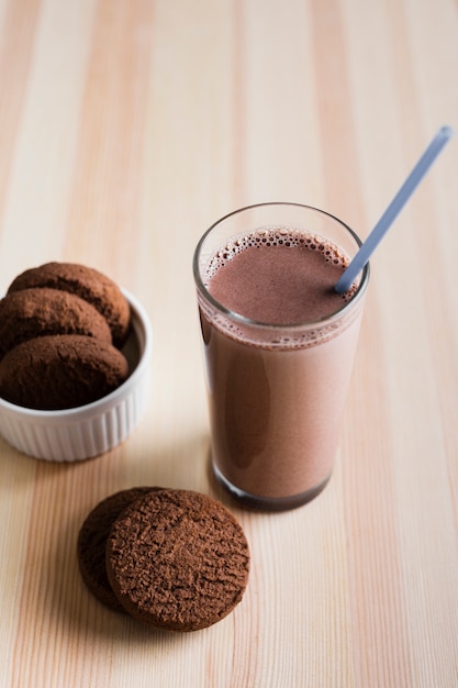 Foto gratuita leche de chocolate de alto ángulo con galletas