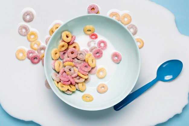 Leche derramada y cereales por toda la mesa y cuchara azul