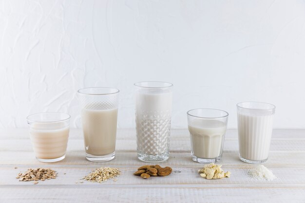 Leche en diferentes vasos y cereales