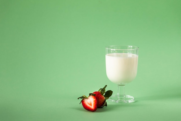 Leche y fresas frescas sobre un fondo verde dieta saludable y estilo de vida nutricional