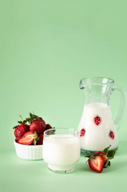 Leche y fresas frescas sobre un fondo verde dieta saludable y estilo de vida nutricional