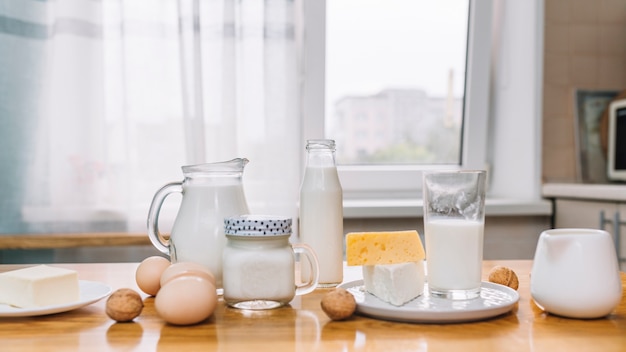 Leche; queso; Huevos y nueces en una mesa de madera en cocina