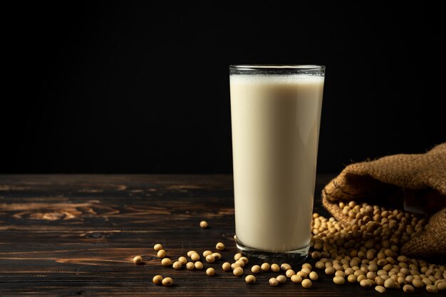 Leche de soja y haba de soja en la tabla de madera.