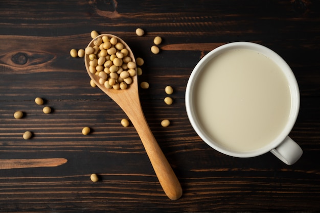 Leche de soja y haba de soja en la tabla de madera.