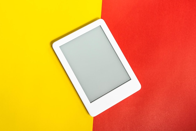 Lector de libros electrónicos sobre fondo amarillo y rojo.