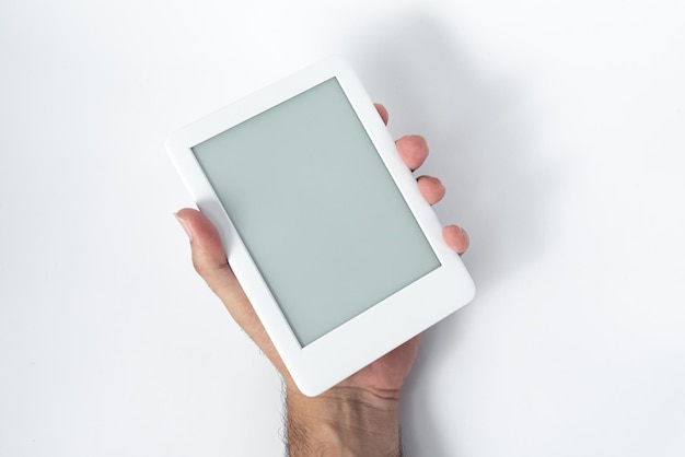 Lector de libros electrónicos sobre un fondo blanco aislado sostenido por una mano masculina