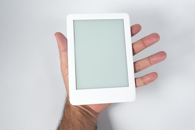 Lector de libros electrónicos sobre un fondo blanco aislado sostenido por una mano masculina