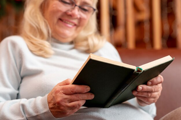 Lectura de mujer sonriente de ángulo bajo