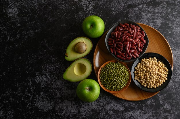 Legumbres y frutas en un piso de cemento negro.