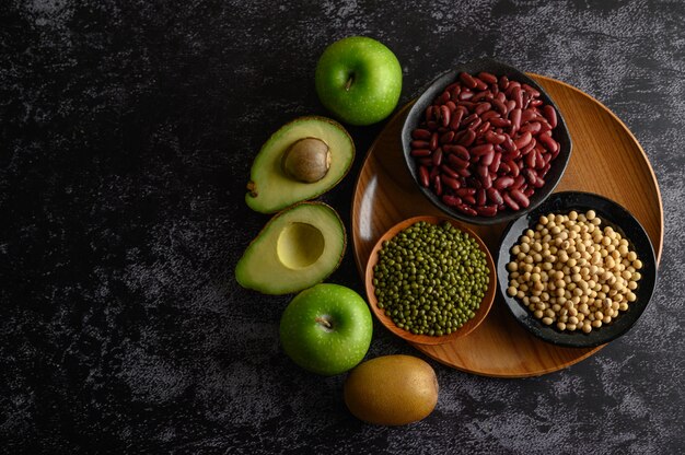 Legumbres y frutas en un piso de cemento negro.