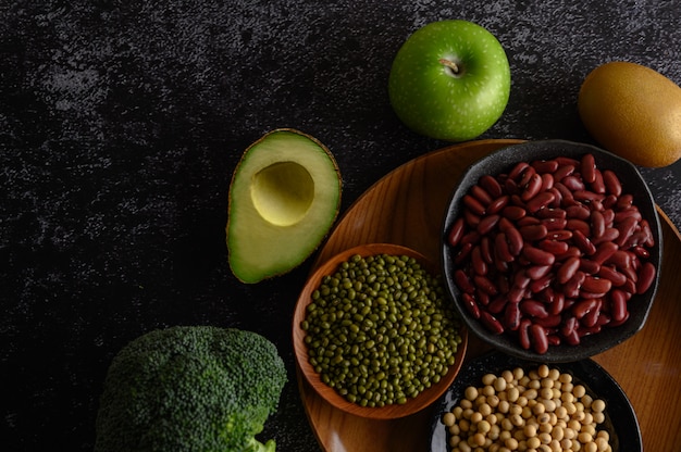 Foto gratuita legumbres y frutas en un piso de cemento negro.