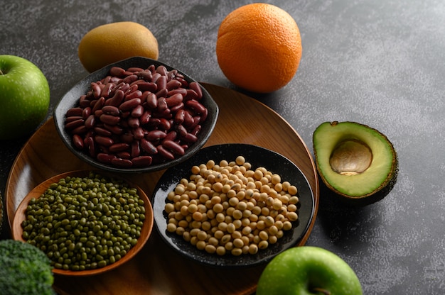 Foto gratuita legumbres y frutas en un piso de cemento negro.