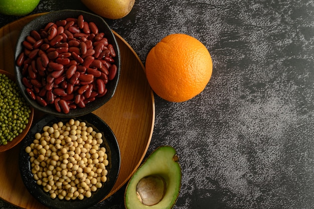 Foto gratuita legumbres y frutas en pisos de cemento negro.