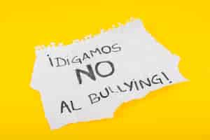 Foto gratuita lema español en la hoja de papel contra el bullying