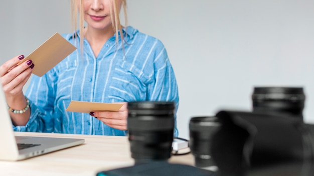 Lente de cámara profesional y mujer mirando fotos