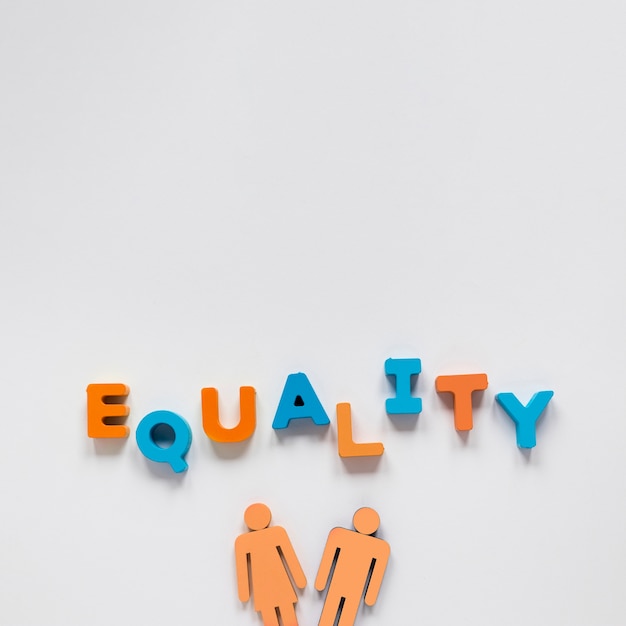 Letras de igualdad con hombre y mujer de juguete