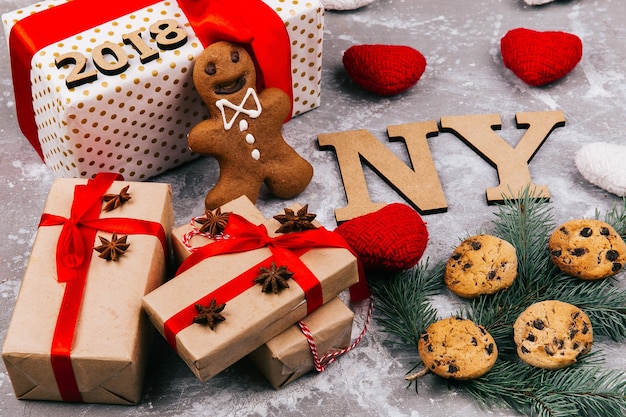 Letras de madera &#39;NY 2019&#39; se encuentran en el suelo rodeadas de galletas, ramas de abeto y cajas de regalo