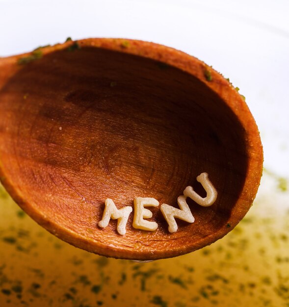 Letras de pasta con palabra de menú en cuchara de madera