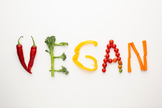 Letras veganas hechas de verduras sobre fondo blanco.