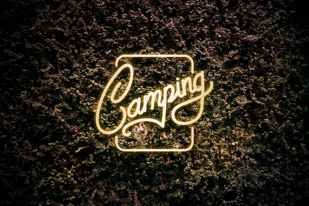 Letrero de camping amarillo neón en hojas