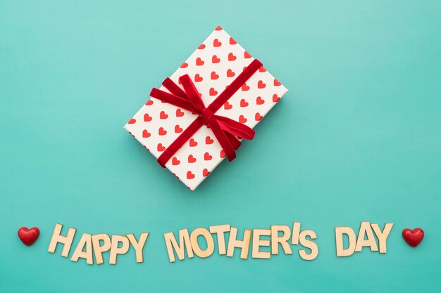 Lettering "happy mother's day" con caja de regalos y corazones