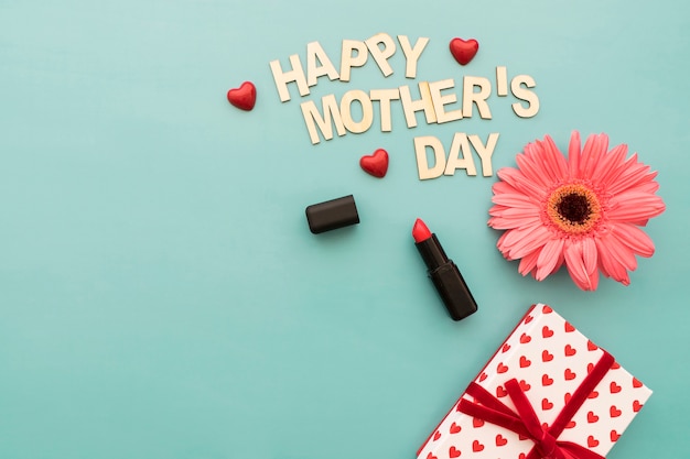 Lettering "happy mother's day" con pintalabios, caja de regalos y flor