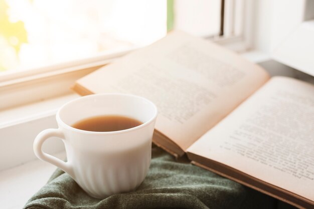 Leyendo un libro y bebiendo café