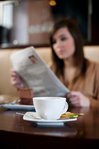 Leyendo el periódico en el café