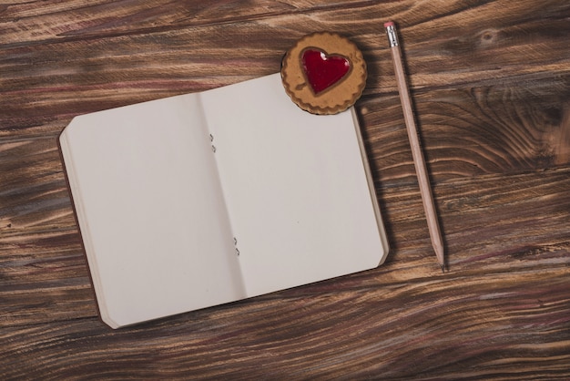 Foto gratuita libreta con un corazón y un lápiz al lado