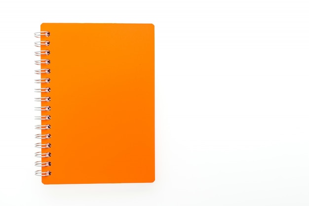 Foto gratuita libreta naranja en un fondo blanco