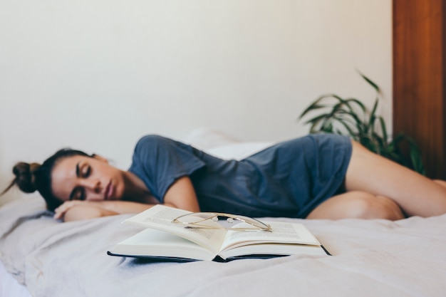 Foto gratuita libro abierto cerca de mujer dormida