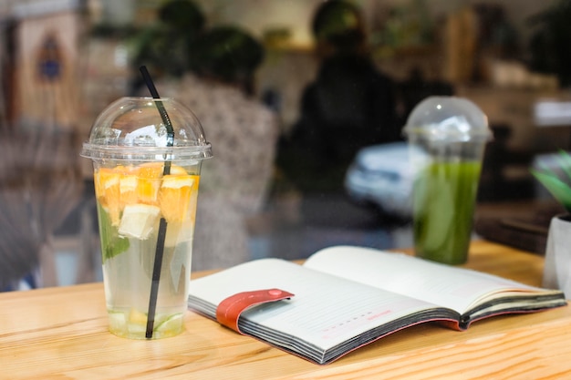 Foto gratuita libro abierto y jugos frescos en la cafetería.