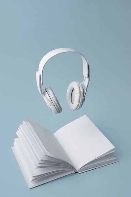 Libro y auriculares con fondo azul.