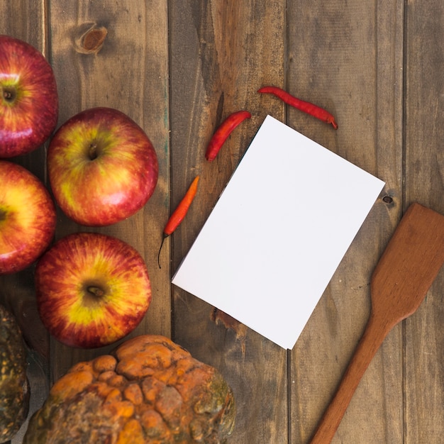 Libro blanco cerca de frutas y verduras