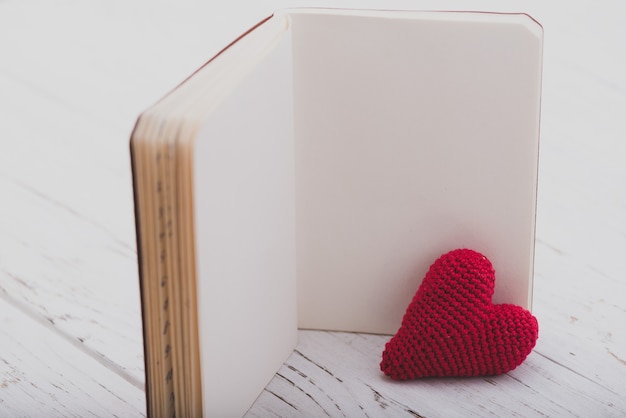 Foto gratuita libro en blanco con un corazón al lado