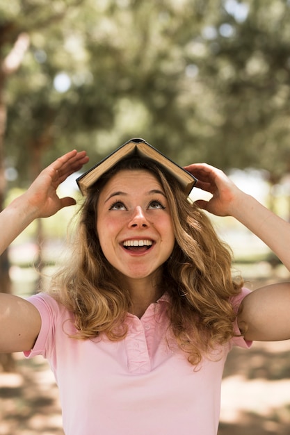 Libro de equilibrio de estudiante adolescente en la cabeza