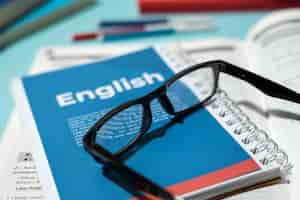 Foto gratuita libro de ingles con gafas en la mesa