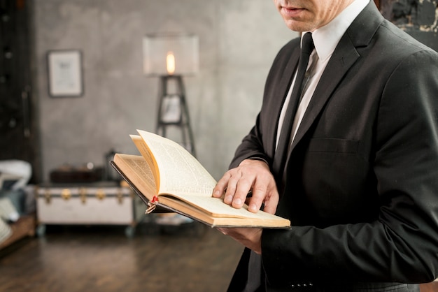 Foto gratuita libro de lectura elegante adulto del hombre de negocios