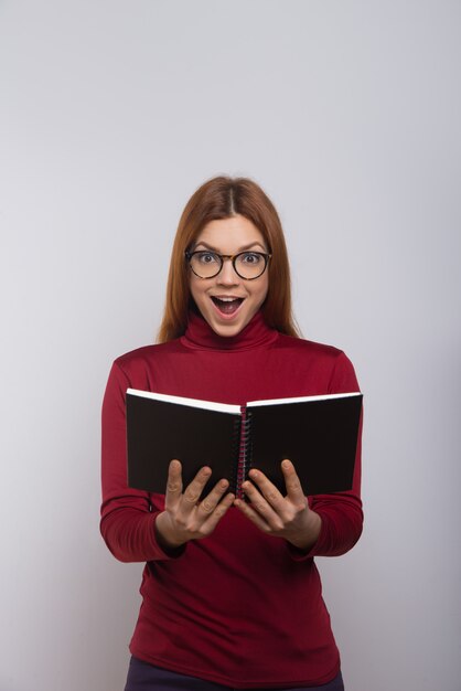 Libro de lectura de estudiante universitario femenino emocionado