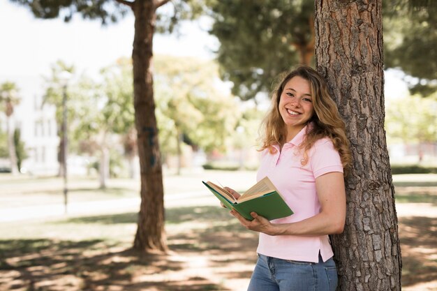 Libro de lectura joven de la muchacha del adolescente en parque