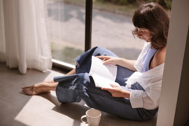 El libro de lectura de la mujer de cabello moreno de vista lateral