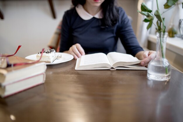 Libro de lectura de mujer de cultivo en café