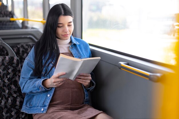 Libro de lectura de mujer embarazada de tiro medio