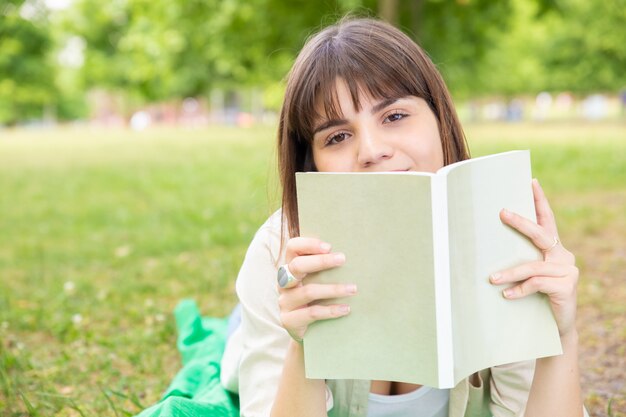 Libro de lectura de mujer joven en el parque
