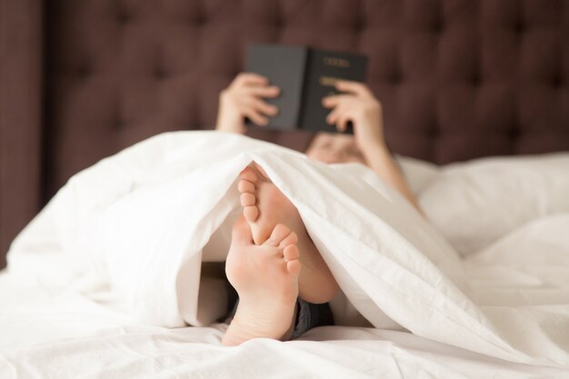 Libro de lectura de la mujer en la mañana en su dormitorio